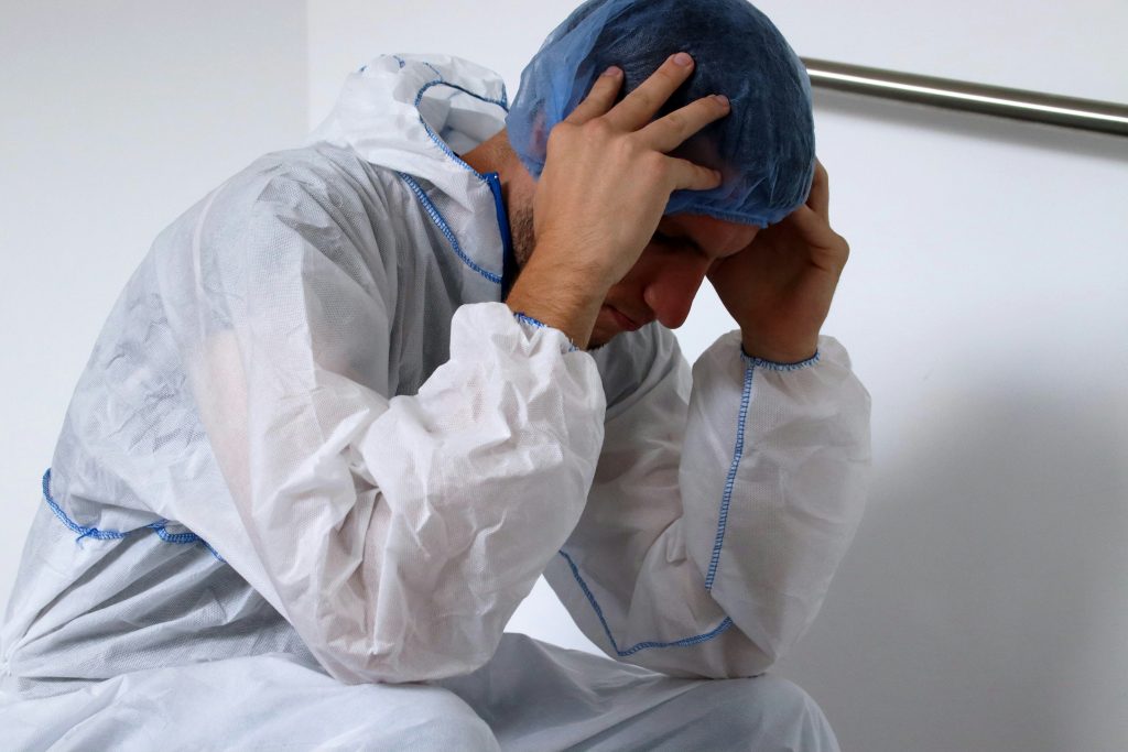 doctor sitting quietly reflecting on emotional burnout and career grief in medicine