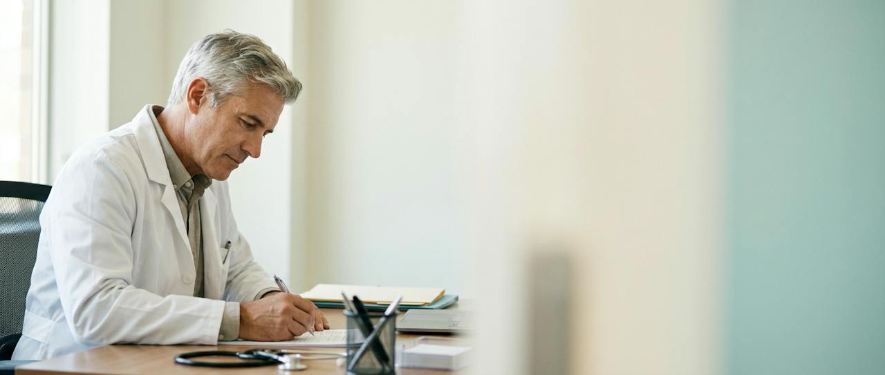 Physician working through a workbook at his desk